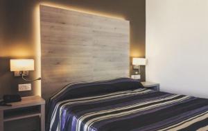 1 dormitorio con cabecero de madera grande y 1 cama en Il Palazzin Hotel en St Paul's Bay
