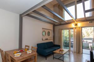 a living room with a blue couch and a table at Elite City Apartments & Maisonettes in Lefkada