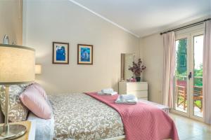 sypialnia z łóżkiem z różowym kocem i oknem w obiekcie Bay Lodge Alykanas w Alikanás +13 zdjęć