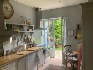 a kitchen with a counter and a clock on the wall at 'Mulberry House' - A Darling Abode Nr Brantome in La Tour-Blanche