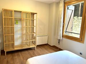 1 dormitorio con cama y estante para libros en Apartament al centre d'Esterri amb vistes úniques by RURAL D'ÀNEU, en Esterri d'Àneu