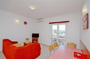 ein Wohnzimmer mit einem roten Sofa und einem Tisch in der Unterkunft Apartments Pisac in Ražanj