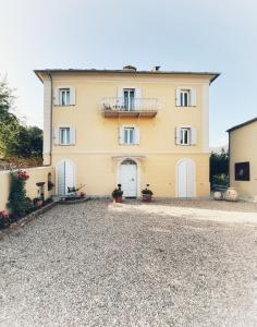 ein großes gelbes Haus mit weißen Türen und einem Balkon in der Unterkunft A Villa di Rutali in Rutali