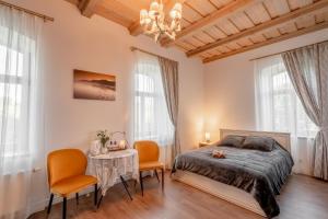 a bedroom with a bed and a table and chairs at Dēseles dzirnavas - Guest House in Embūte