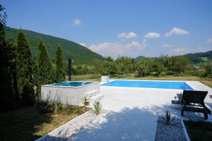 a swimming pool in a garden with a hill in the background at Holiday home Residence Green in Visoko
