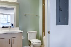 a bathroom with a toilet and a sink and a mirror at Pioneer Square studio w gym bbq nr stadium SEA-586 in Seattle +17 photos