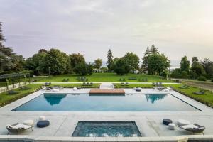 una gran piscina con césped y árboles en Palace Grand Hotel Varese, en Varese