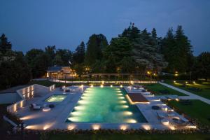 a pool with lights in a backyard at night at Palace Grand Hotel Varese in Varese
