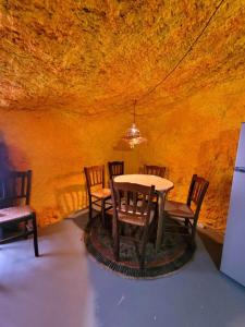 uma sala de jantar com uma mesa e cadeiras numa caverna em ACORAN FAMILY em Firgas