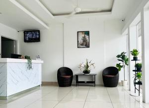 um átrio branco com duas cadeiras e um balcão com uma televisão em V Hotel Melaka (Near Jonker Street) em Malaca