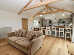 a living room with a couch and a kitchen at Cotswold View in Chipping Norton