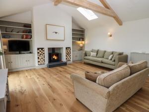 a living room with a couch and a fireplace at Cotswold View in Chipping Norton