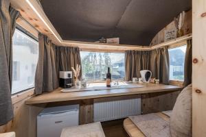 a kitchen with a sink and a window in a trailer at Mountain Caravan - Zirben Nestl in Nova Ponente