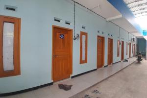 a row of doors on a wall in a hallway at SPOT ON 92814 Gioba Kost Syariah in Grobogan