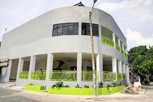 a large white building with people on the balcony at Capital O 92804 La Tansa Syariah Hotel in Cibeber