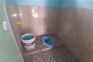 a small bathroom with a bucket and a toilet at SPOT ON 92814 Gioba Kost Syariah in Grobogan