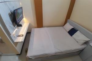 ein kleines Schlafzimmer mit einem Bett und einem TV in der Unterkunft OYO Life 92812 Galih Kostel 2 Syariah in Grobogan