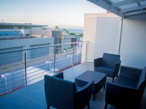 a balcony with chairs and a table on a building at Sapphire Seas Beach Apartment in Humewood