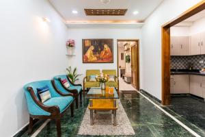 a living room with chairs and a table at Homlee-3bhk Green Luxury in SDEL in New Delhi