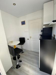 a small kitchen with a table and two chairs at MMA apartament in Klaipėda