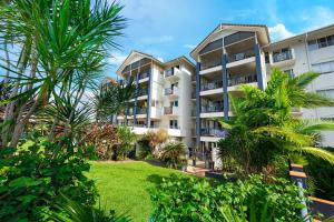 een appartementencomplex met palmbomen ervoor bij Cairns Esplanade 2BR Waterfront Apartment Sleeps 6 in Cairns