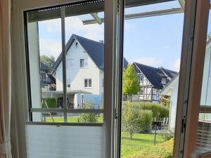 a window with a view of a house at Ferienwohnung Klute in Allendorf