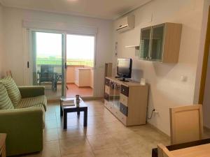 a living room with a tv and a couch and a table at Apartamento con vistas al mar y montaña in Oropesa del Mar