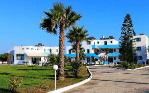 two palm trees in front of a white building at Anthia Apartments in Marmari