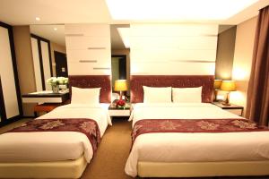 a hotel room with two beds in a room at Paradise Spa Hotel in Port Dickson