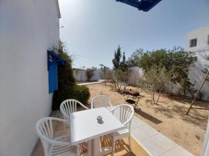 een witte tafel en stoelen op een patio bij Tamalou Djerba in Midoun