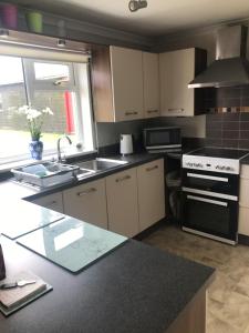 a kitchen with a sink and a stove top oven at Park Cottage in Saint Marys