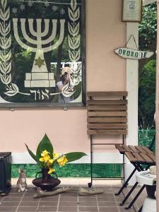 a vase of yellow flowers sitting on a patio at OKUNO IE in Oshima