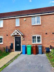 a brick building with four trash cans in front of it at AMILA House Manchester, Modern, Spacious, Sleeps 7 With Parking in Manchester