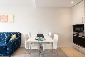 a dining room with a white table and a couch at Nouvo Apartments in Wellington