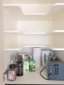 a kitchen shelf with a coffee maker and other kitchen items at Nouvo Apartments in Wellington