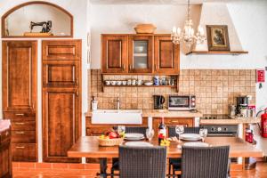 una cucina con armadi in legno e tavolo con sedie di Villa Marko a Marasi