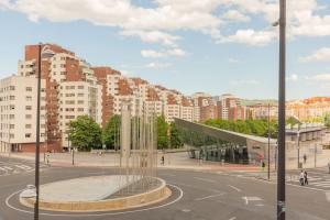 a city with a fountain in the middle of a street at Frente al parque, en el centro in Bilbao