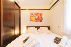 a bedroom with two beds and a painting on the wall at Frente al parque, en el centro in Bilbao