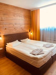 a bedroom with a large bed with a wooden wall at Alpine luxury two bed-two bathrooms apartment B25 in Borovets