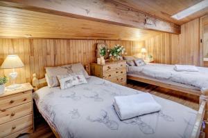 a bedroom with two beds in a wooden cabin at Chalet Chenavray - OVO Network in Manigod
