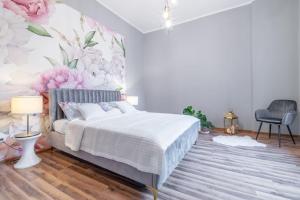 1 dormitorio con 1 cama con pared de flores en Opera, en Bytom