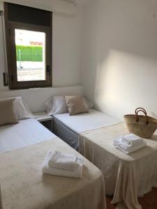 Cette chambre comprend 2 lits et une fenêtre. dans l'établissement Kalma House, à Torroella de Montgrí