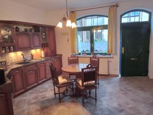 a kitchen with a table and chairs and a kitchen with a sink at Kauris Apartament in Gdańsk +10 photos