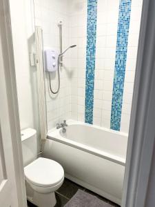 y baño con aseo, bañera y lavamanos. en 2 bed flat, 1 bed flat Torquay, Torbay, Devon, en Torquay