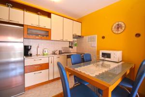 a kitchen with a dining table and blue chairs at Apartment Stinjan 2287 in Pula