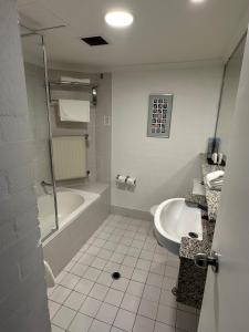 a bathroom with a tub and a toilet and a sink at Grand Country Lodge Motel in Mittagong