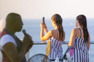 two women taking a picture of a tennis player at The Diplomat Hotel in Sliema