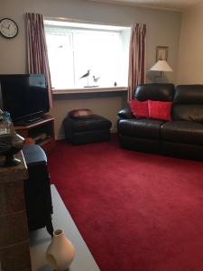 a living room with a couch and a red carpet at Park Cottage in Saint Marys