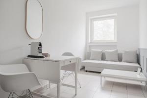 a white room with a desk and a couch at Cozy Apartment in Prime Location with Balcony - Hotel Comfort in 2 Room Apartment in Cologne Neumarkt - City Loft 11 - in Cologne