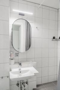 La salle de bains blanche est pourvue d'un lavabo et d'un miroir. dans l'établissement Cozy Apartment in Prime Location with Balcony - Hotel Comfort in 2 Room Apartment in Cologne Neumarkt - City Loft 11 -, à Cologne
